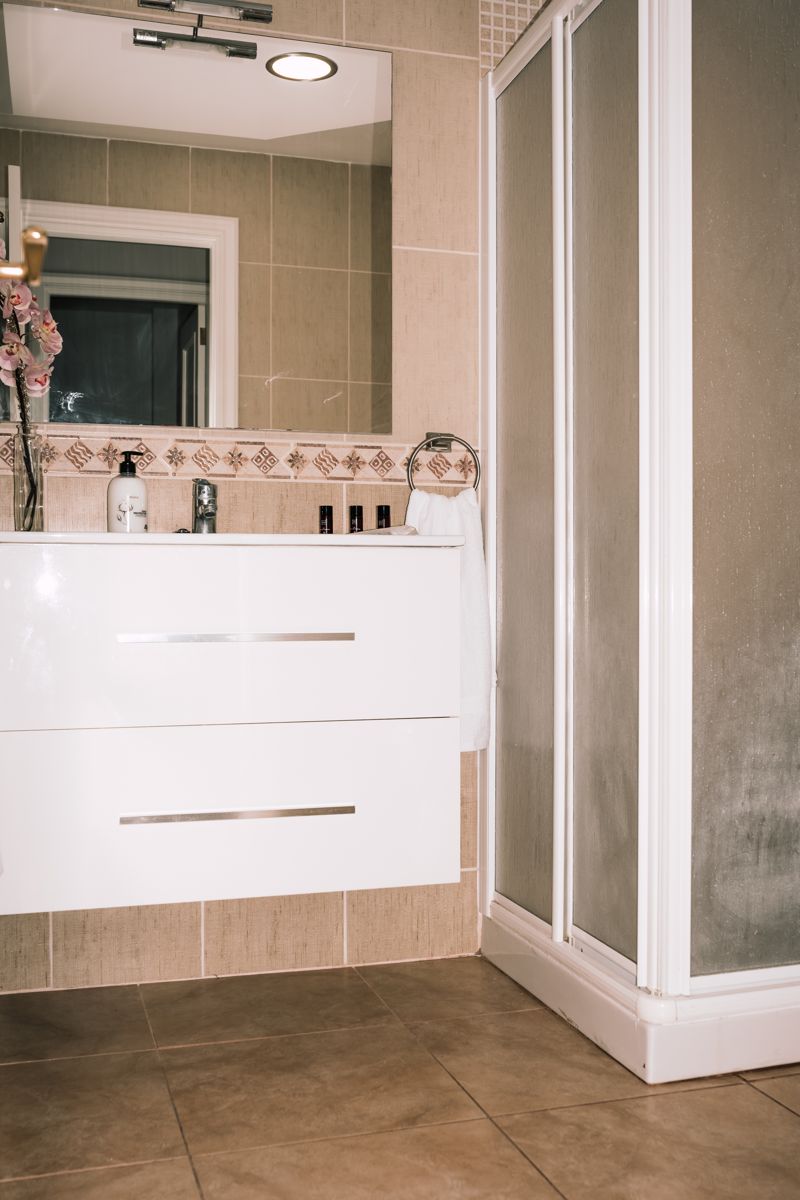 Bagno moderno con lavandino, specchio e doccia a Tenerife.