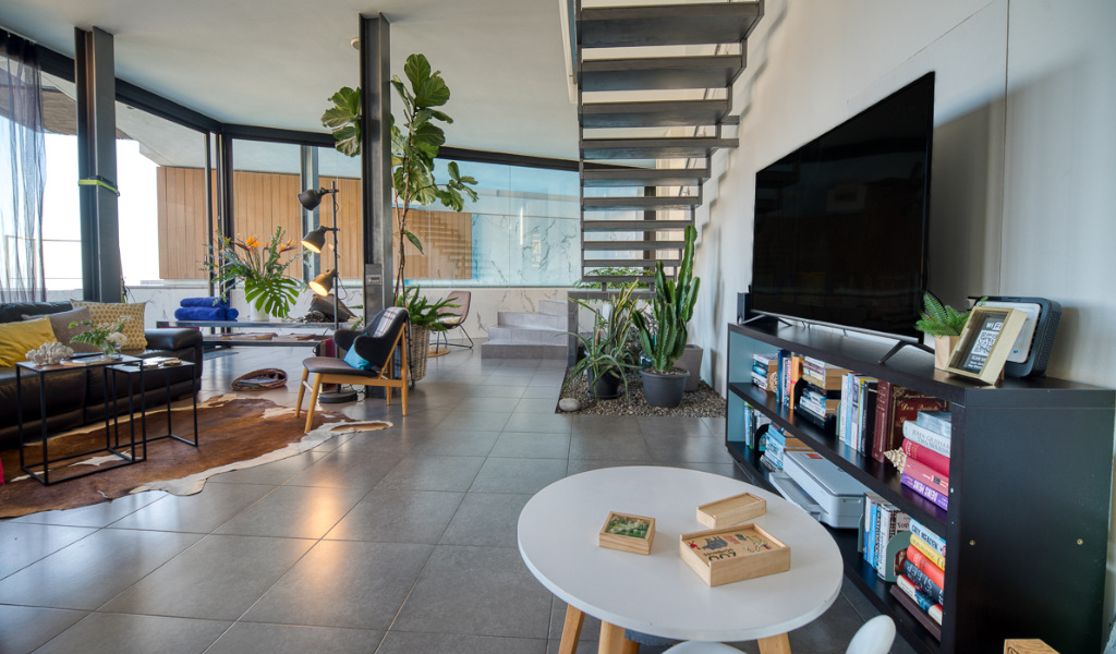 Soggiorno moderno con piante e scala in una casa a Tenerife.