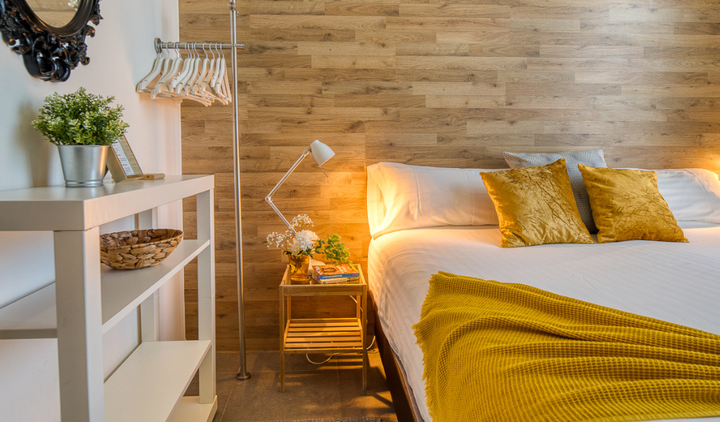 Camera da letto con letto matrimoniale, cuscini gialli e comodino a Tenerife.
