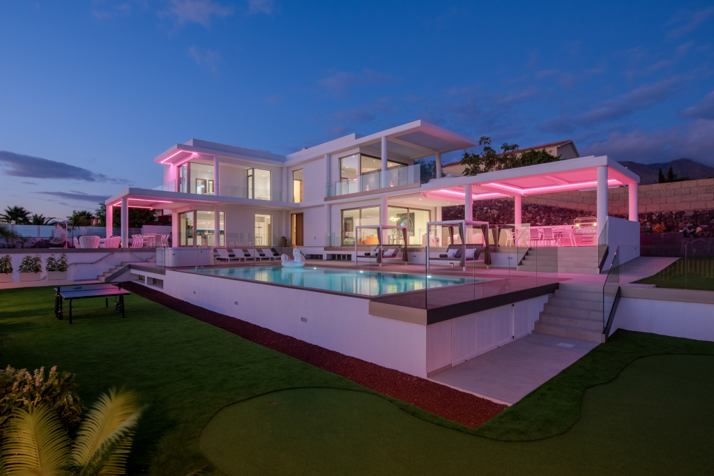 Villa moderna con piscina e luci rosa al tramonto a Tenerife.
