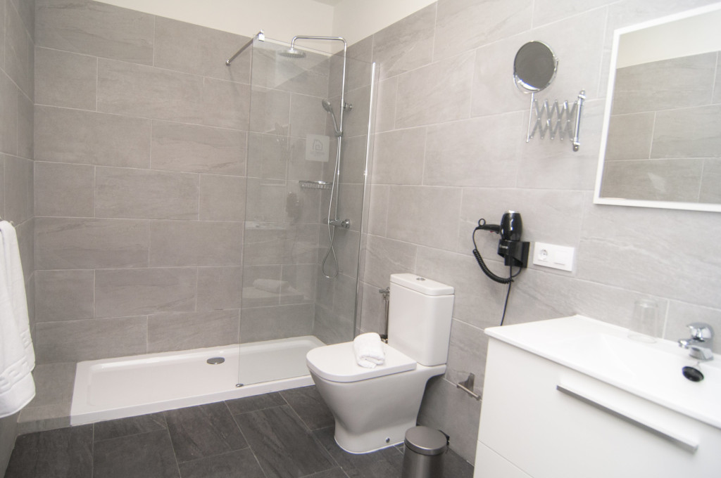 Bagno moderno con doccia in vetro, WC e lavandino in un hotel a Tenerife.
