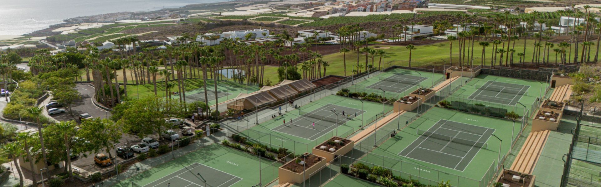 Campi da tennis all'aperto a Tenerife con persone che giocano su diversi campi.