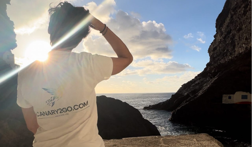 Persona guarda il mare al tramonto, maglietta CANARY2GO.COM. Vista da Tenerife.