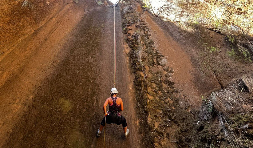 Persona che fa rappelling su una parete rocciosa a Tenerife.