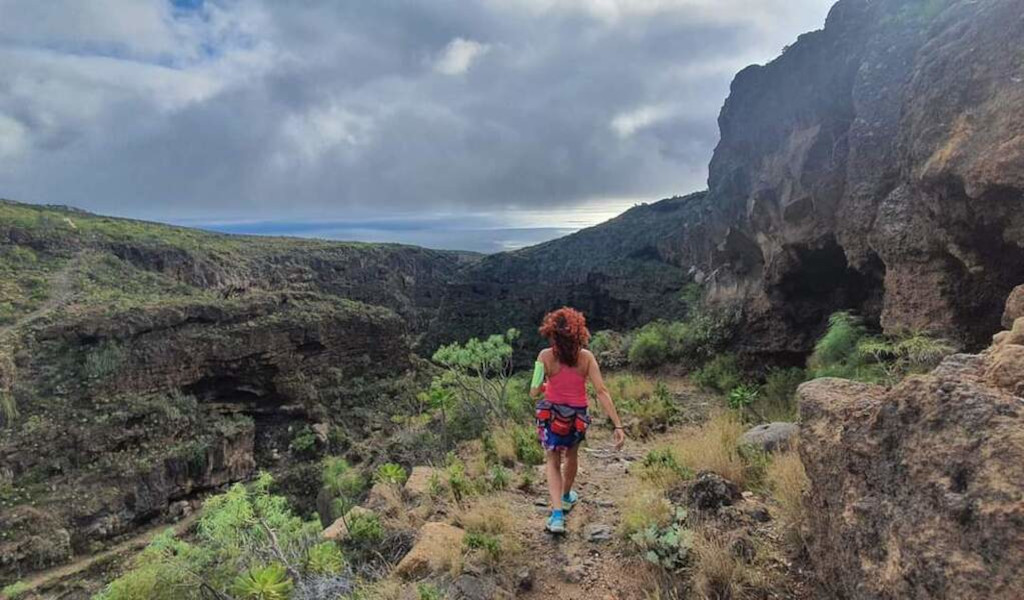 Escursionista cammina nel paesaggio montuoso di Barranco del Infierno, Tenerife.