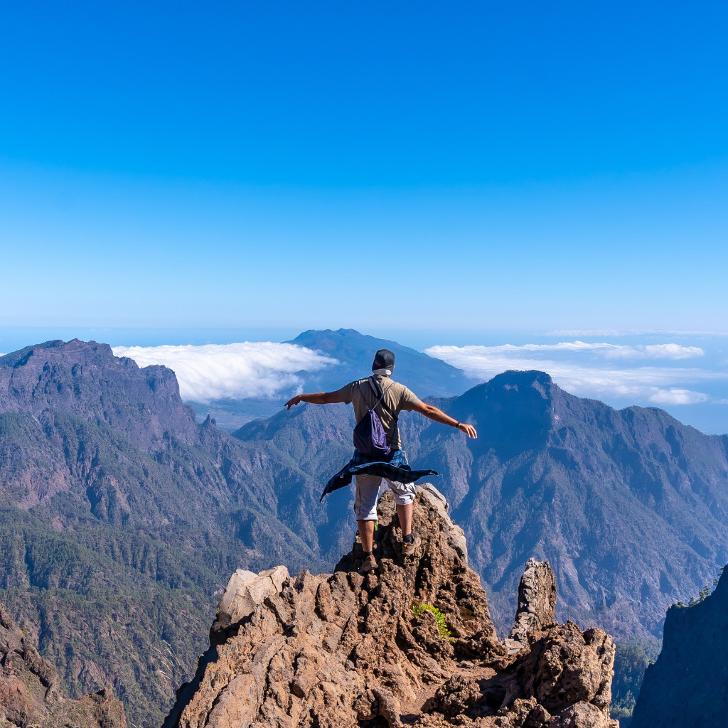 Persona in piedi su una montagna a Tenerife con vista panoramica sulle nuvole.
