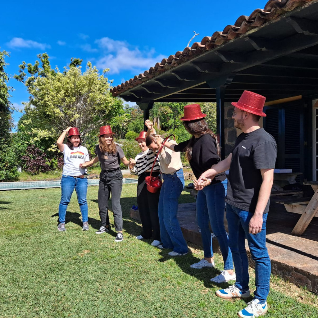 Gruppo di persone con cappelli rossi nel giardino di una casa a Tenerife.