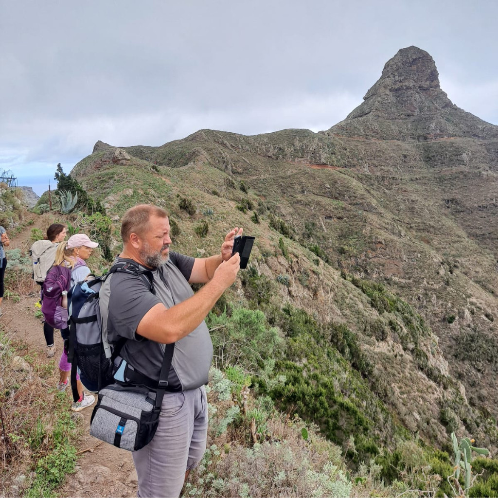 Persone che camminano lungo un sentiero a Tenerife con le montagne sullo sfondo.
