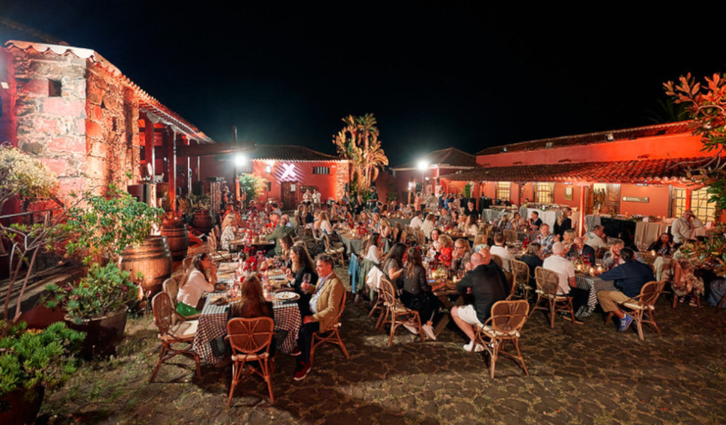 Persone che cenano all'aperto in una finca a Tenerife durante la notte.