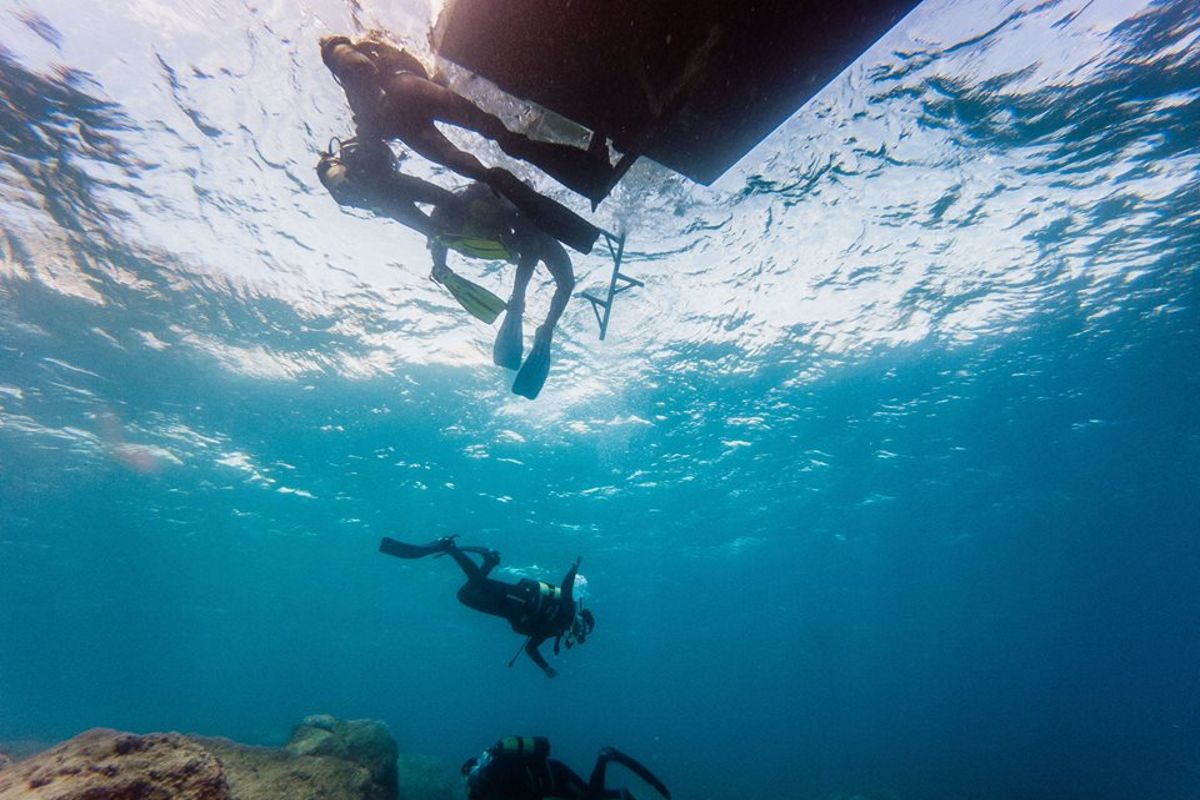Subacquei che esplorano il mare sotto una barca a Tenerife.