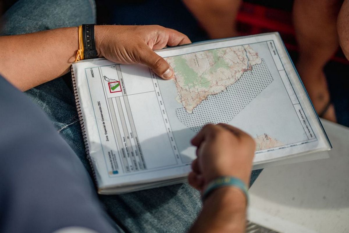 Persona che tiene una mappa di Tenerife in un quaderno a spirale.