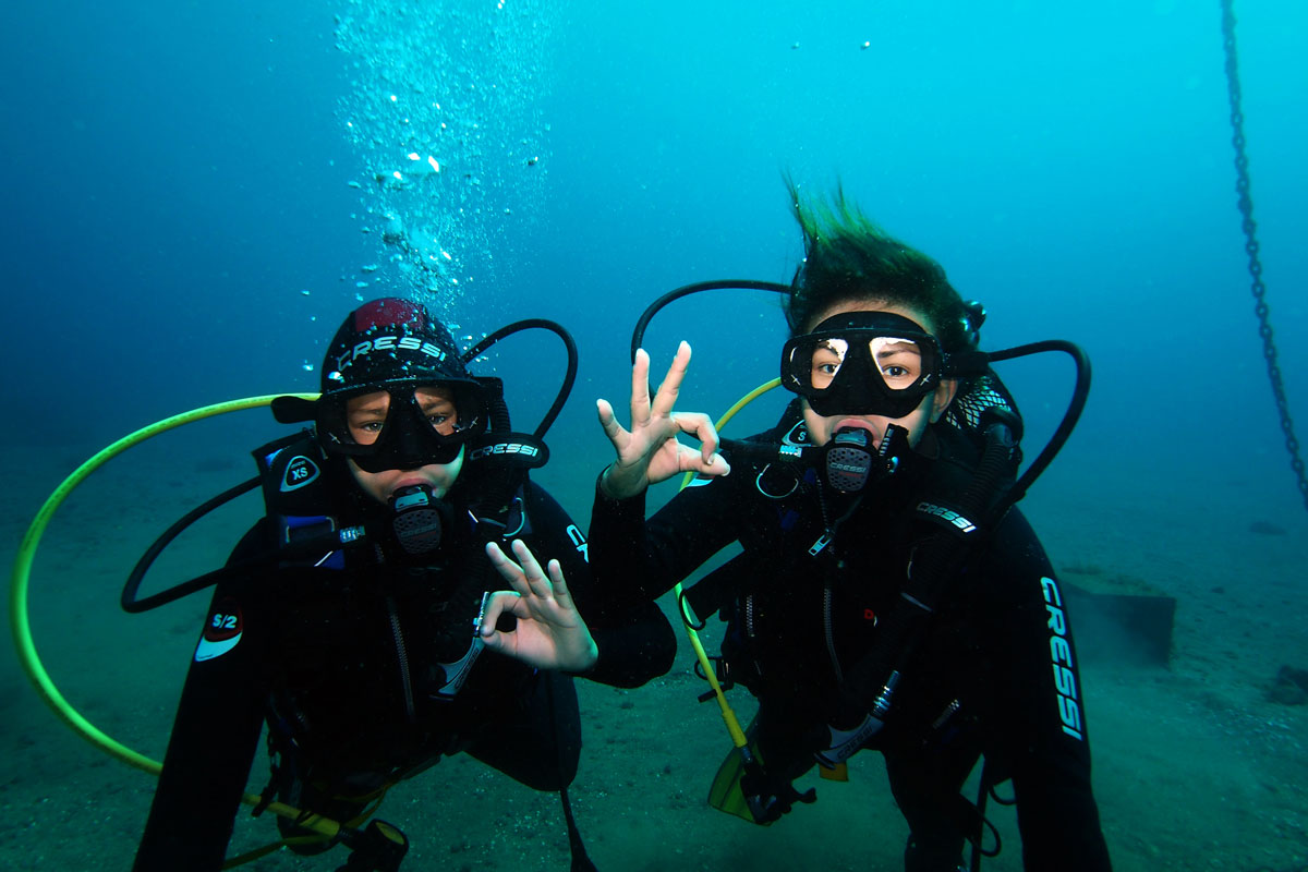 Due subacquei che stanno facendo il segno ok sott'acqua a Tenerife.