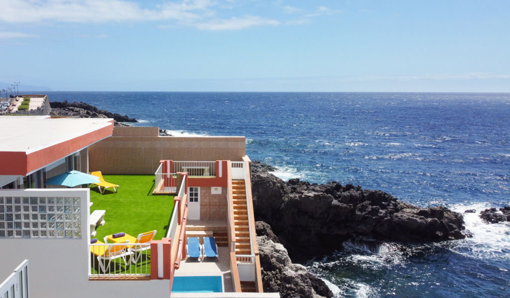 Terrazza con prato e sdrai sul mare su una scogliera a Tenerife.