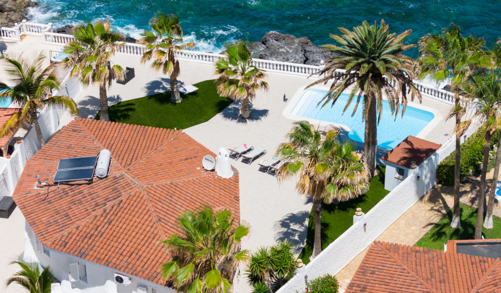 Vista aerea della terrazza con piscina, palme e mare a Tenerife.