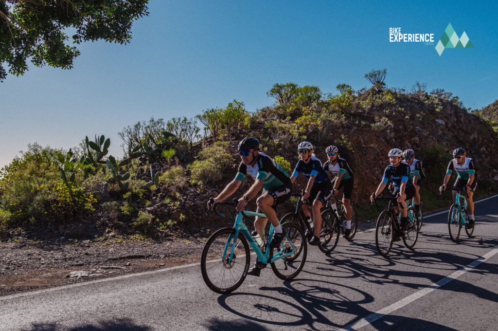 Ciclisti su un percorso montano a Tenerife, con il logo Bike Experience.