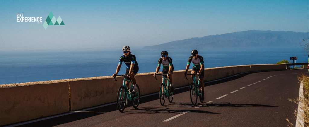 Ciclisti sulla strada con oceano e vista su Tenerife. Testo: Esperienza in bici.