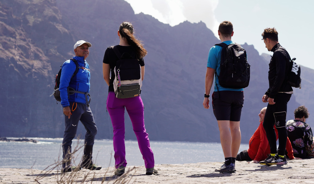 Gruppo di persone con zaini davanti a scogliere a Tenerife.