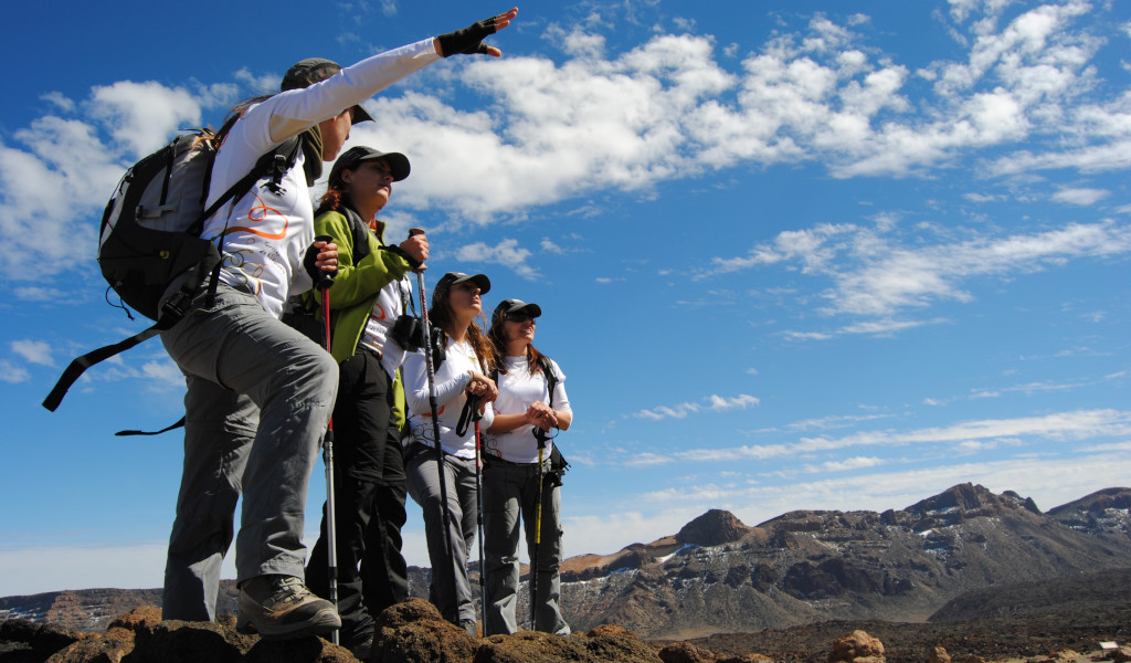 Gruppo di escursionisti nel Parco Nazionale del Teide, Tenerife, con montagne sullo sfondo.