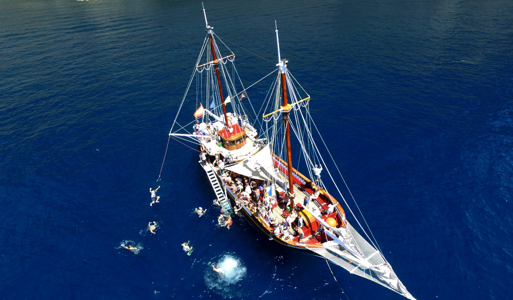 Barca turistica con persone che nuotano vicino a Tenerife.