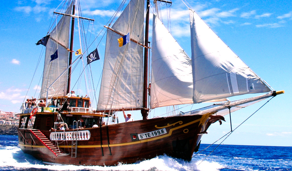 Barca a vela che naviga al largo della costa di Tenerife in una giornata di sole.
