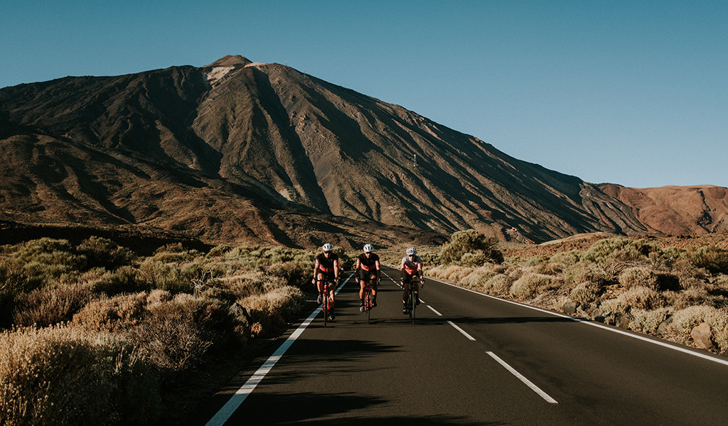 Ciclisti sulla strada verso il Monte Teide, Tenerife, con la montagna sullo sfondo.