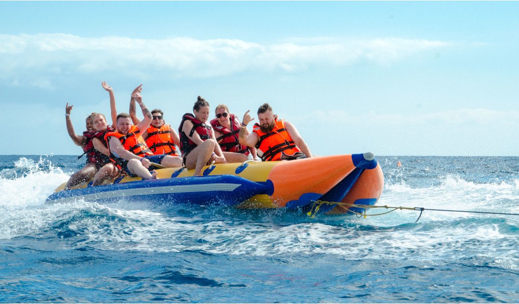 Persone su una banana boat gonfiabile sopra il mare durante un'attività acquatica a Tenerife.