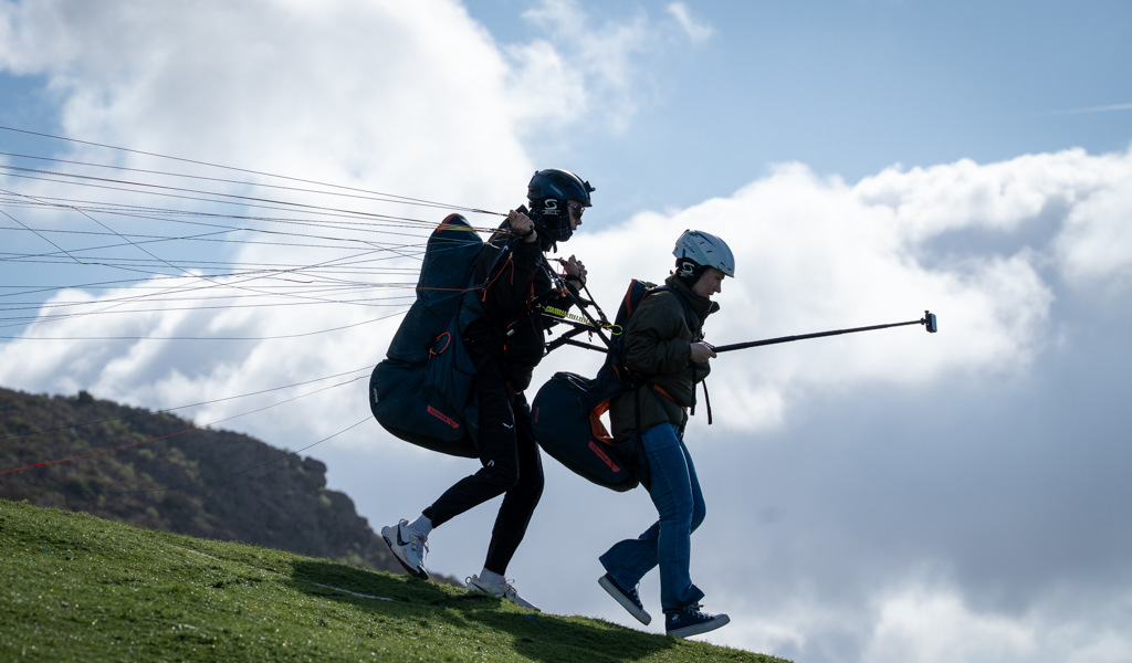 Due persone che decollano in parapendio a Tenerife sotto un cielo nuvoloso.