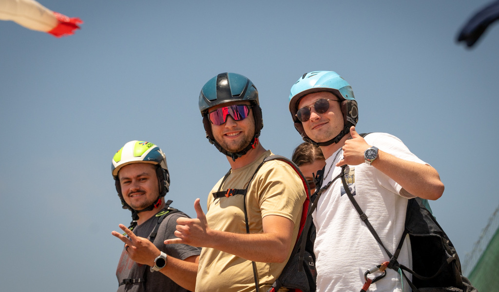 Tre persone con elmetti sorridono facendo un pollice in su in una giornata di sole a Tenerife.