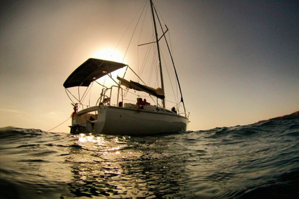 Barca a vela in mare al tramonto vicino a Tenerife.