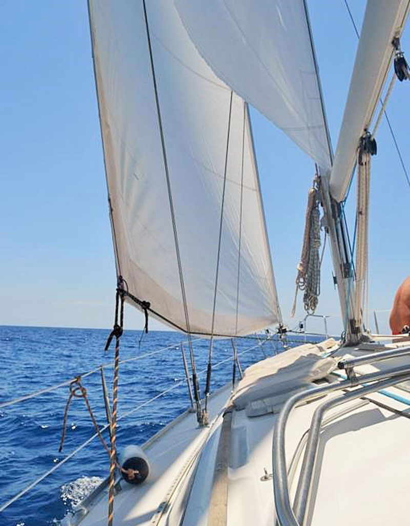Navigare su una barca a vela nel mare vicino a Tenerife con cieli sereni.