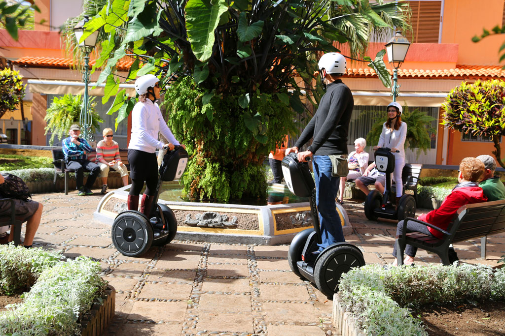 Persone su segway intorno a una fontana in una piazza a Tenerife.