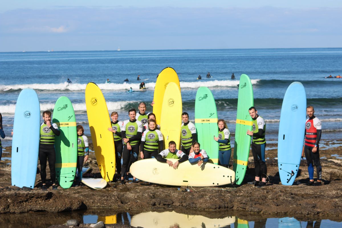 Gruppo di surfisti con tavole colorate sulla spiaggia di Tenerife.