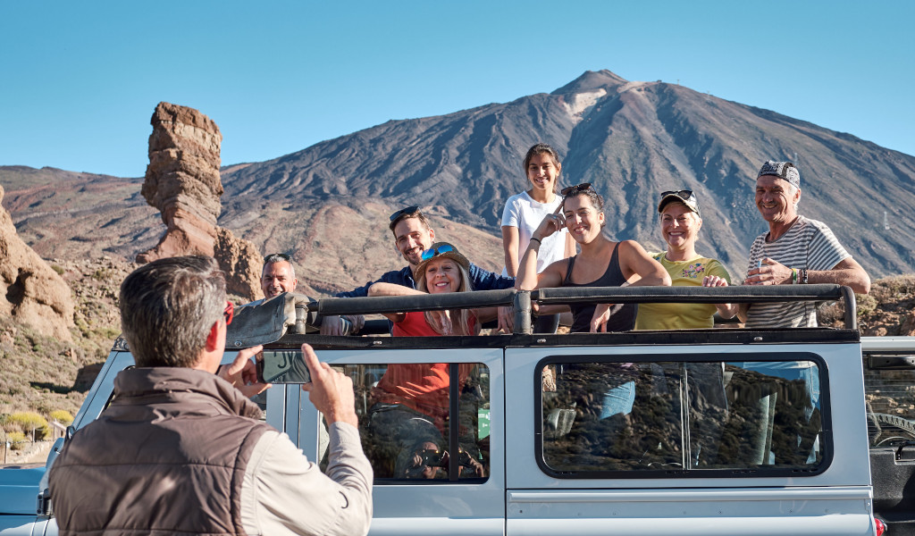 Gruppo di persone su una jeep davanti al Monte Teide a Tenerife.