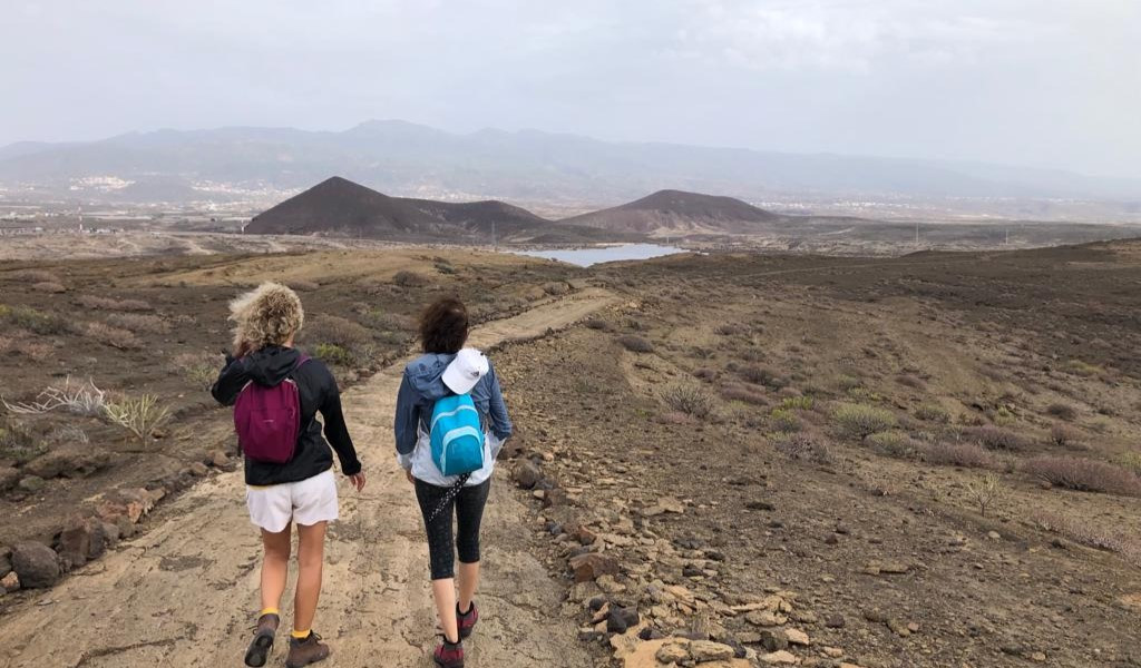 Due persone che camminano lungo un sentiero nel paesaggio di Tenerife.