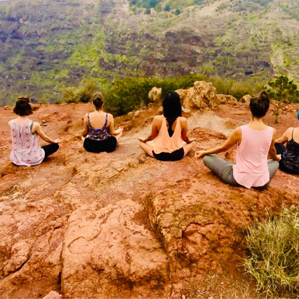 Persone che meditano all'aperto su una scogliera a Tenerife.
