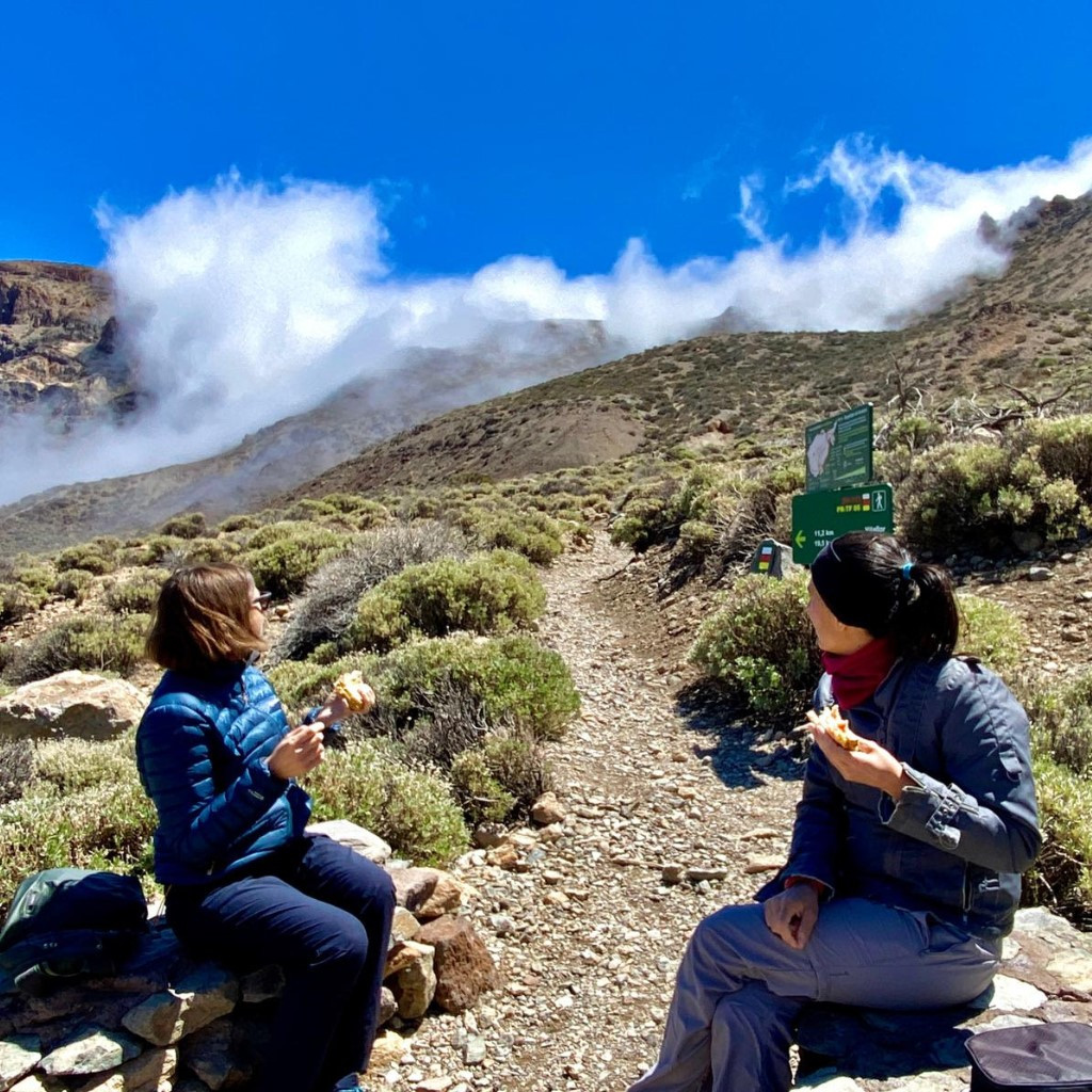 Persone sedute a mangiare su un sentiero nel Parco Nazionale del Teide, Tenerife.