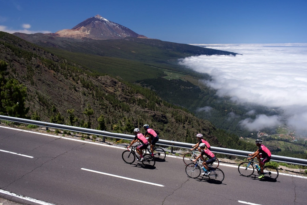 Ciclisti che scalano vicino al Monte Teide a Tenerife con vista sulla valle e sul mare di nuvole.