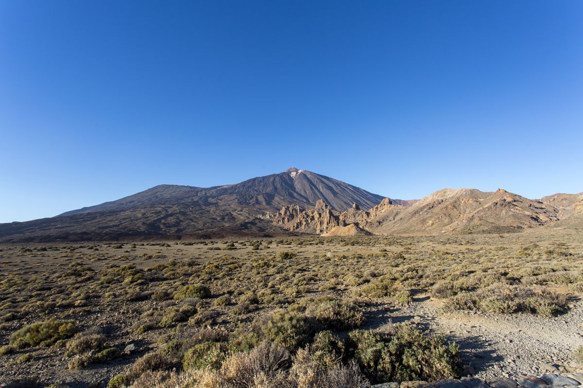 Paesaggio del Monte Teide a Tenerife con cieli sereni e terreno montuoso.