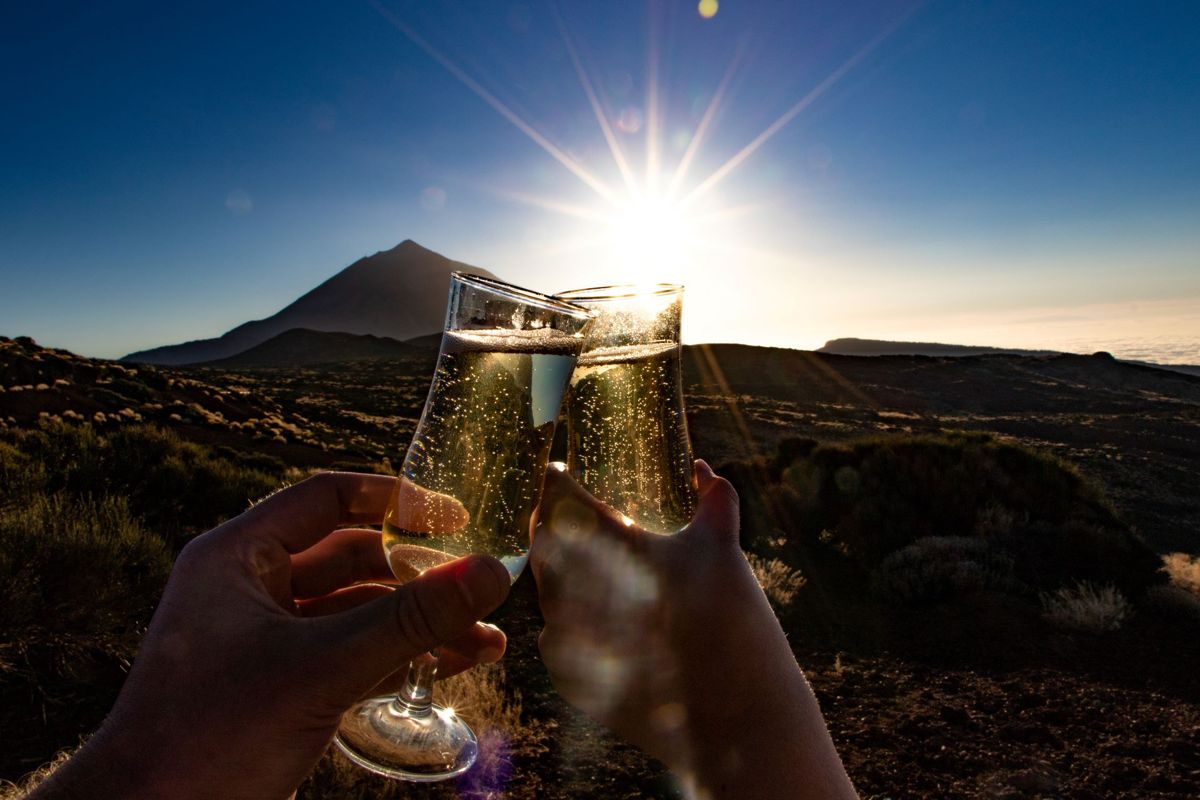 Brindisi con bicchieri di champagne al tramonto vicino al Monte Teide, Tenerife.