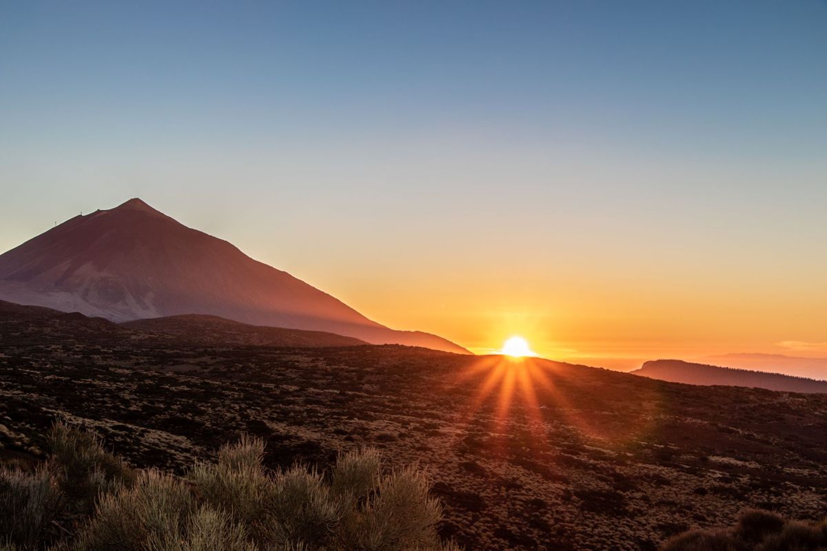 L'alba sul Monte Teide, Tenerife, con il sole che spunta da dietro l'orizzonte.