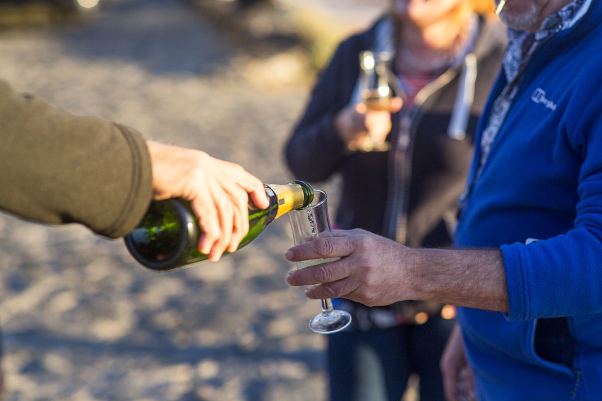 Versare champagne in un bicchiere sulla spiaggia di Tenerife.