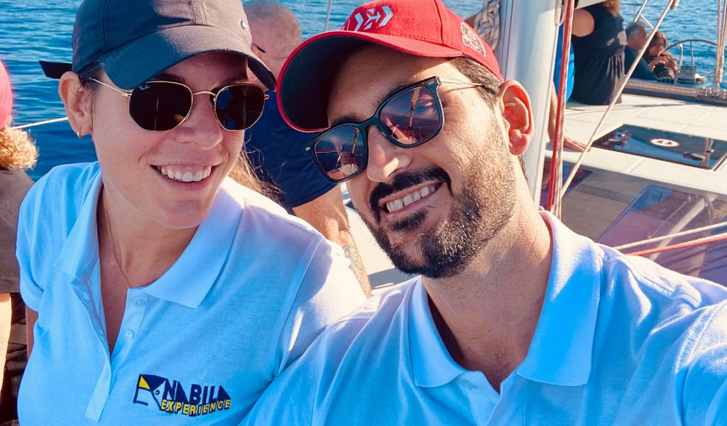 Persone che sorridono su una barca a Tenerife, con il logo Anaga Experience su una maglietta.