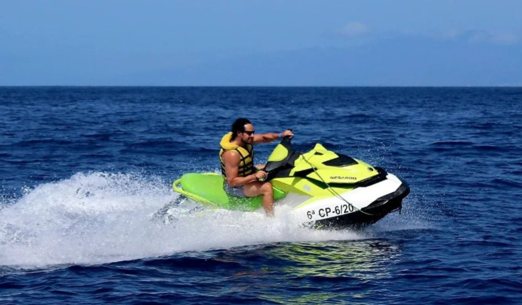 Persona che guida una moto d'acqua nel mare di Tenerife. Testo visibile: 6° CP-20/6.