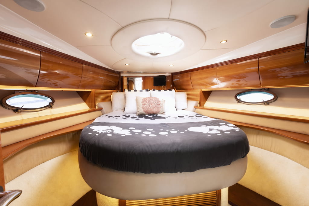 Cabina con letto rotondo e finestra su uno yacht, Puerto de la Cruz, Tenerife.