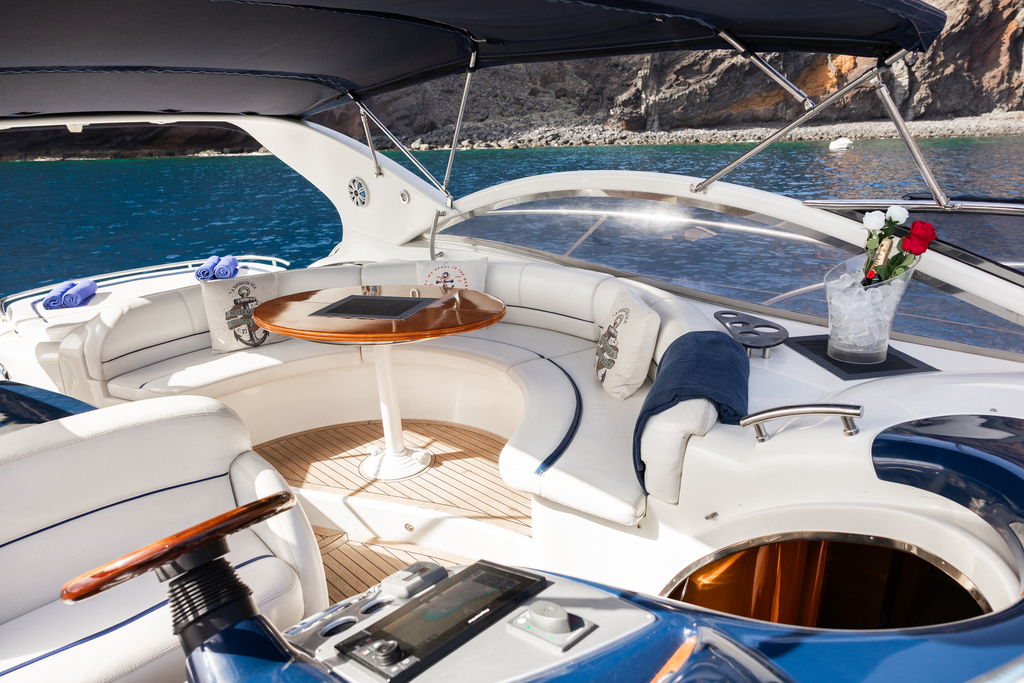 Interno yacht con sedili in pelle bianca e tavolo rotondo sulla costa di Tenerife.