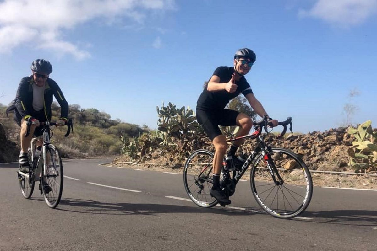 Ciclisti sulla strada vicino a Cactus a Tenerife sotto cieli sereni.