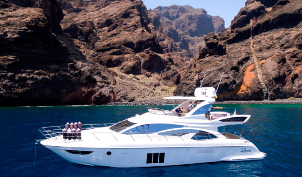Yacht che naviga davanti alle scogliere di Los Gigantes, Tenerife.