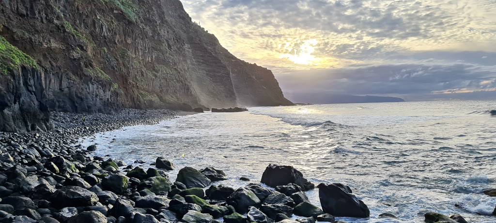Costa rocciosa al tramonto a Tenerife con scogliere e mare calmo.