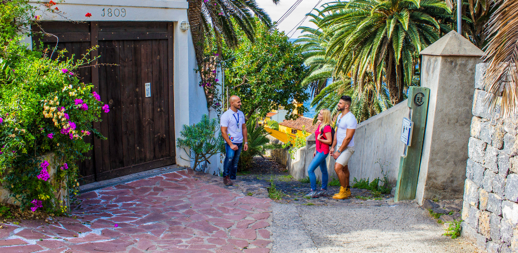 Tre persone che parlano in una strada circondata da palme a Tenerife.
