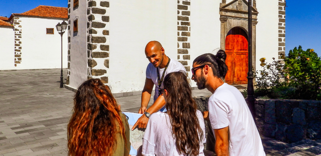 Gruppo di persone che guardano una mappa davanti a una chiesa a La Laguna, Tenerife.